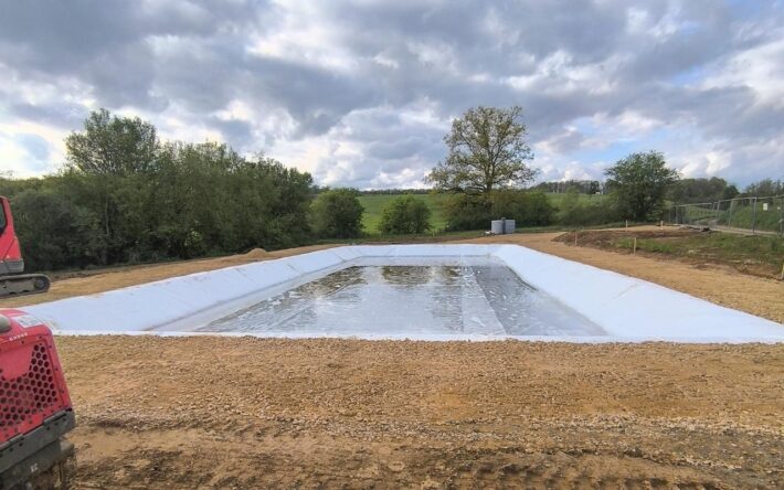Un revêtement est disposé au fond du bassin avant l'installation des graviers - Crédits photo : Commune de Linay