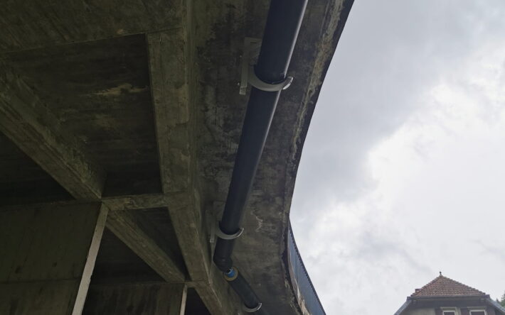 Passage en encorbellement sous le pont du Dessoubre - Les tuyaux sont isolés par l’extérieur pour résister aux contraintes thermiques, des joints développés par l'entreprise Von Roll prennent en compte la dilatation. Crédit photo : CCPM
