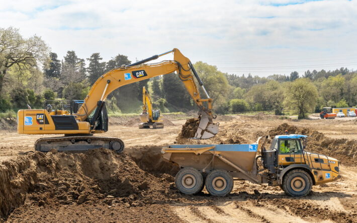 Phase de terrassement des bassins de rétention : une pelle hydraulique charge un tombereau sur la zone de chantier. - Crédit photo : Grand Avignon/Clotilde Arnaud