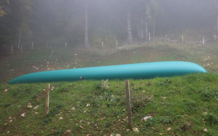 Une citerne souple de 100 m3, alimentée par une source, est reliée à un abreuvoir et sert de réserve incendie, à proximité de bâtiments d’alpage.- Crédit photo : cabinet GTR