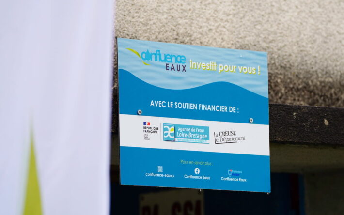 Pancarte installée sur le mur du local technique des réservoirs semi-enterrés de Trois-Fonds. Inaugurée le 21 octobre 2025, elle présente l’ensemble des financeurs du projet d’interconnexion - Crédits photo : Confluence Eaux.